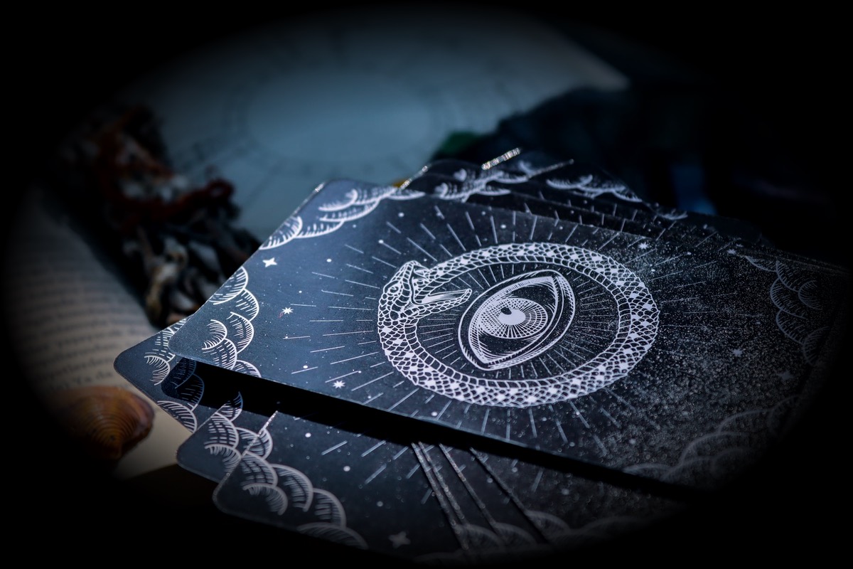Des cartes de tarot à côté d'un livre ouvert